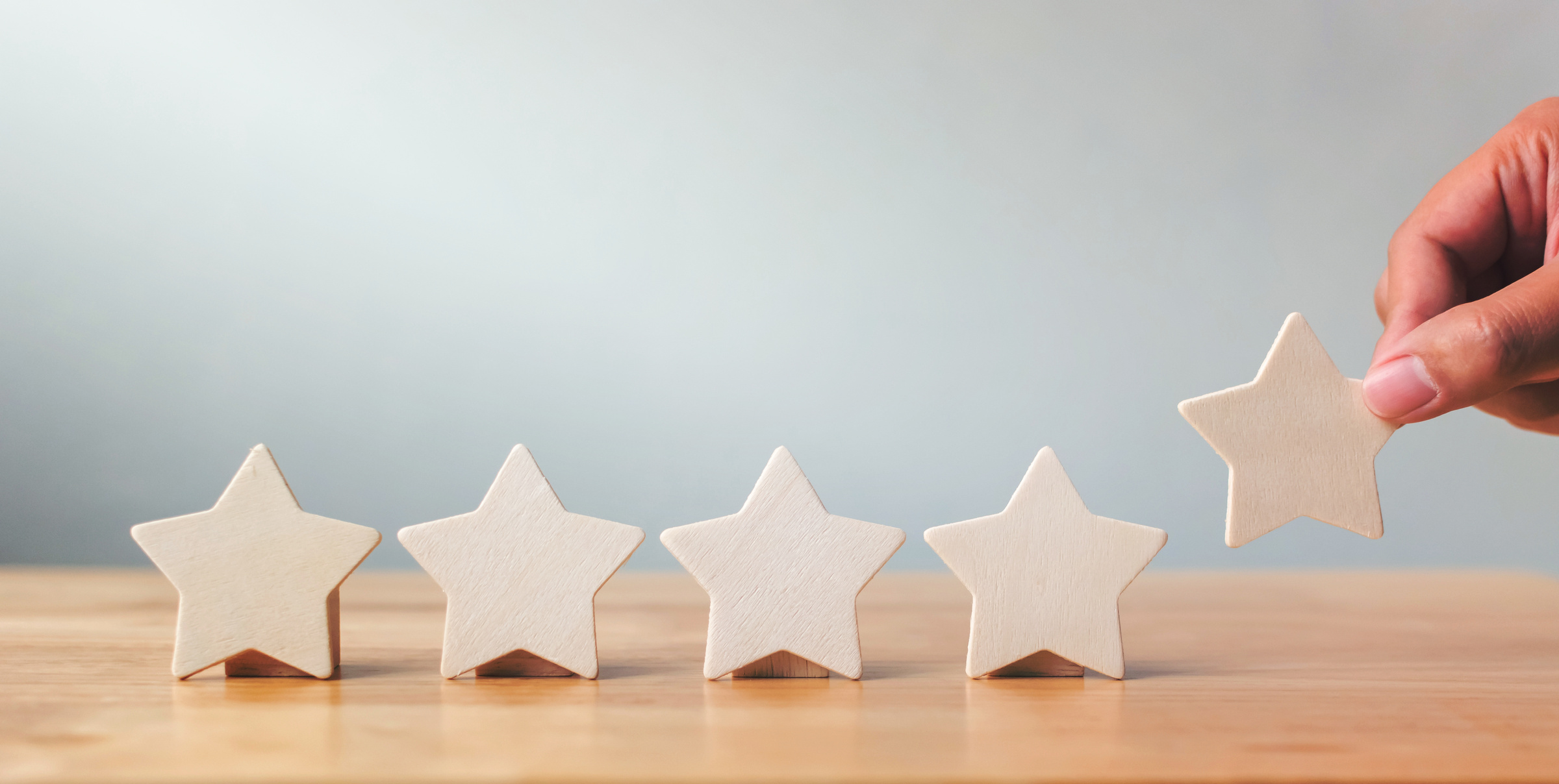 Hand Putting Wooden Five Star Shape on Table. the Best Excellent Business Services Rating Customer Experience Concept